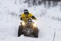 The quad bike's driver rides over snow track Royalty Free Stock Photo