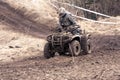 Quad competition. Man driving quad during the race among mud.