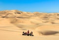 Quad driving people - two happy bikers in sand desert. Royalty Free Stock Photo