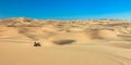 Quad driving in sand desert. ATV in middle of nowhere. Royalty Free Stock Photo