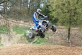 Quad rider is high jumping in the difficult terrain