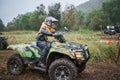 Quad rider jumping on a muddy forest trail