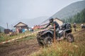 Quad rider jumping on a muddy forest trail