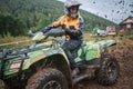 Quad rider jumping on a muddy forest trail