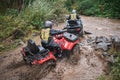 Quad rider jumping on a muddy forest trail