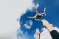 Quadcopter with camera in blue sky with clouds. hand and flying drone on background of sunny sky. space for text. wedding Royalty Free Stock Photo