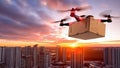 Quadcopter drone with cardboard box flying over the city at sunset