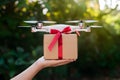 Quadcopter drone delivers box with red ribbon, aerial delivery