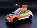 Quadcopter drone take off from orange electric rescue SUV on black background