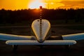 Quadruple aircraft parked at a private airfield. Rear view of a plane with a propeller on a sunset background.