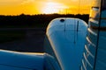 Quadruple aircraft parked at a private airfield. Rear view of a plane with a propeller on a sunset background.