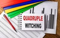 Quadruple Witching text on notebook with pen, folder on a chart background Royalty Free Stock Photo