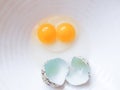 Quail egg with double yolk broken on a white plate. Royalty Free Stock Photo