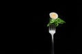 Quail egg with salad on a fork on a black background Royalty Free Stock Photo