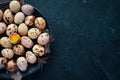 Quail eggs in a black plate. On the old background. Royalty Free Stock Photo