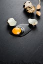 Quail eggs on black stone background, broken, cracked quail egg, yolk of quail egg. Royalty Free Stock Photo