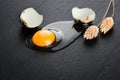 Quail eggs on black stone background, broken, cracked quail egg, yolk of quail egg. Royalty Free Stock Photo