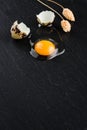 Quail eggs on black stone background, broken, cracked quail egg, yolk of quail egg. Royalty Free Stock Photo