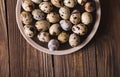 Quail eggs in a brown plate on a wooden table. Rustic Style. Eggs. Easter photo concept