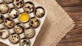 Quail eggs in cardboard packaging on a wooden table, copy space, horizontal banner, flatlay Royalty Free Stock Photo