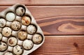 Quail eggs in a carton on a wooden background. Healthy food