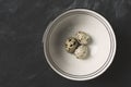 Quail eggs in ceramic bowl on black rustic background Royalty Free Stock Photo