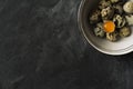 Quail eggs in ceramic bowl on black rustic background Royalty Free Stock Photo