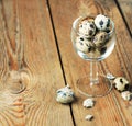 Quail eggs in a glass on a wooden table