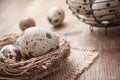 Quail eggs in nest on wooden table with metallic bask