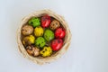 Quail eggs painted in different colors in a light wicker basket