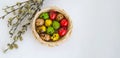 Quail eggs painted in different colors in a light wicker basket