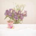 Quail eggs in pink bucket, colorful feathers and fresh flowers, light rustic napkin on table, selective focus. Easter Royalty Free Stock Photo
