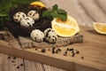 Quail eggs - Quail eggs in a ceramic bowl on old brown wooden surface background, selective focus. Top view. Royalty Free Stock Photo