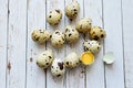 Quail eggs on a white wooden background. Broken egg, yolk. Place for text. Easter holiday background.Proper nutrition. Royalty Free Stock Photo