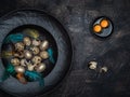 Quail eggs, yolks, golden colored eggs and colorful feathers in black bowl Royalty Free Stock Photo