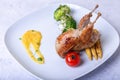 Quail roasted whole with broccoli, mini corn, cherry tomato and orange sauce.