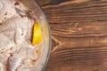 Quails marinated in spices with lemon in a glass saucepan on a wooden background. Close-up. Royalty Free Stock Photo