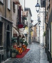 Quaint cobblestone alleyway in Aosta Italy with inviting red carpet entrance to Italian restaurant on left Royalty Free Stock Photo