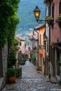 Quaint cobblestone street in a charming Italian village with colorful houses and a view of lush hills