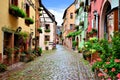 Colorful cobblestone lane in the Alsatian town of Riquewihr, France Royalty Free Stock Photo