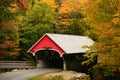 A quaint covered bridge is surrounded by brilliant autumn foliage Royalty Free Stock Photo