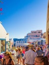 Quaint crowded commercial street and beautiful houses at coast Oia Santorini Greece Royalty Free Stock Photo