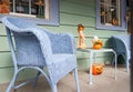 Quaint front porch on street with blue wicker chairs and halloween decorations