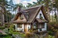 A quaint house with a thatched roof nestled among trees in a forest setting, A cozy cottage nestled in the woods with a thatched