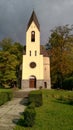 Quaint little country church sitting in a green meadow surrounded by trees in the summer time