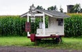 an old wooden and white outhouse with a porch marijuana signs on it