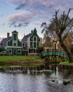 Quaint scene in Zaanse Schans with green buildings and a bridge over the river