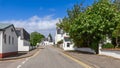 White-rendered houses of Ullapool among vibrant foliage and blossoms, beneath Scotland\'s blue skies