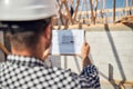 Qualified construction supervisor checking building whiteprints at construction site Royalty Free Stock Photo
