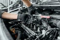 Qualified man in black dirty gloves unscrews old spark plugs Royalty Free Stock Photo